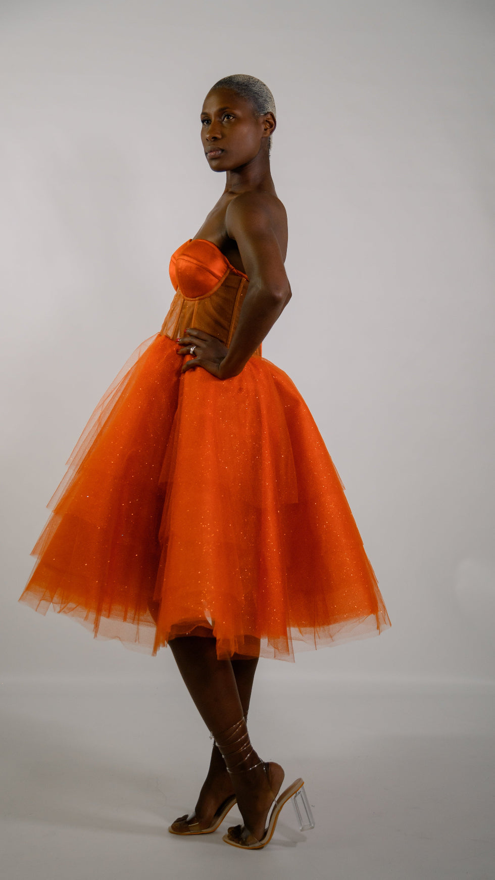 Woman wearing an orange dress against a white background